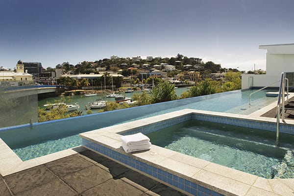 infinity swimming pool with deckchair in Townsville with sun setting