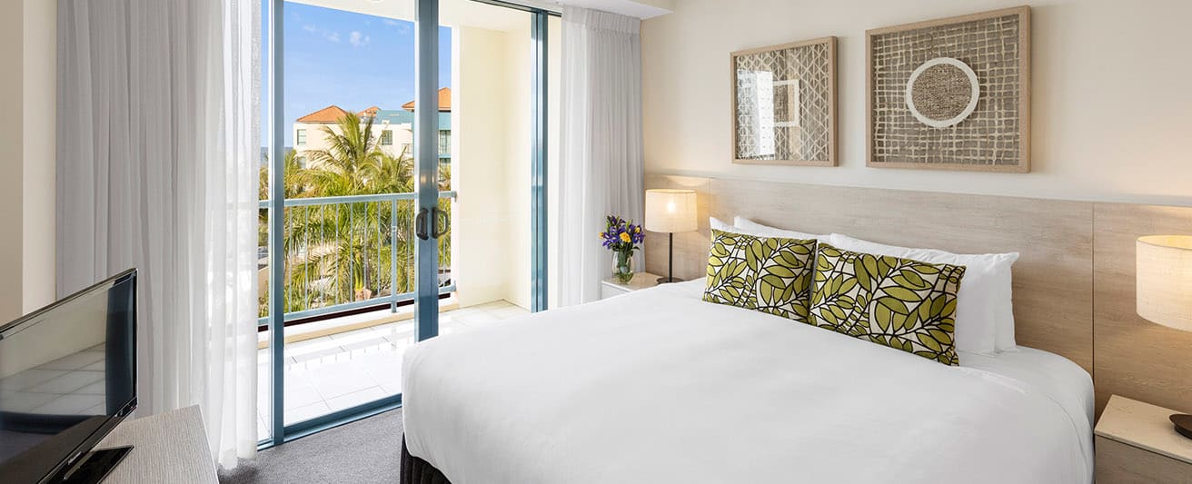 oaks seaforth bedroom with balcony views of ocean palm tress and sunshine coast
