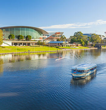 boat on Adelaide river with rowers and building in background