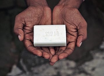 hands holding white bar of soap